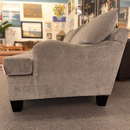 Gray upholstered chair in a room with decorative elements