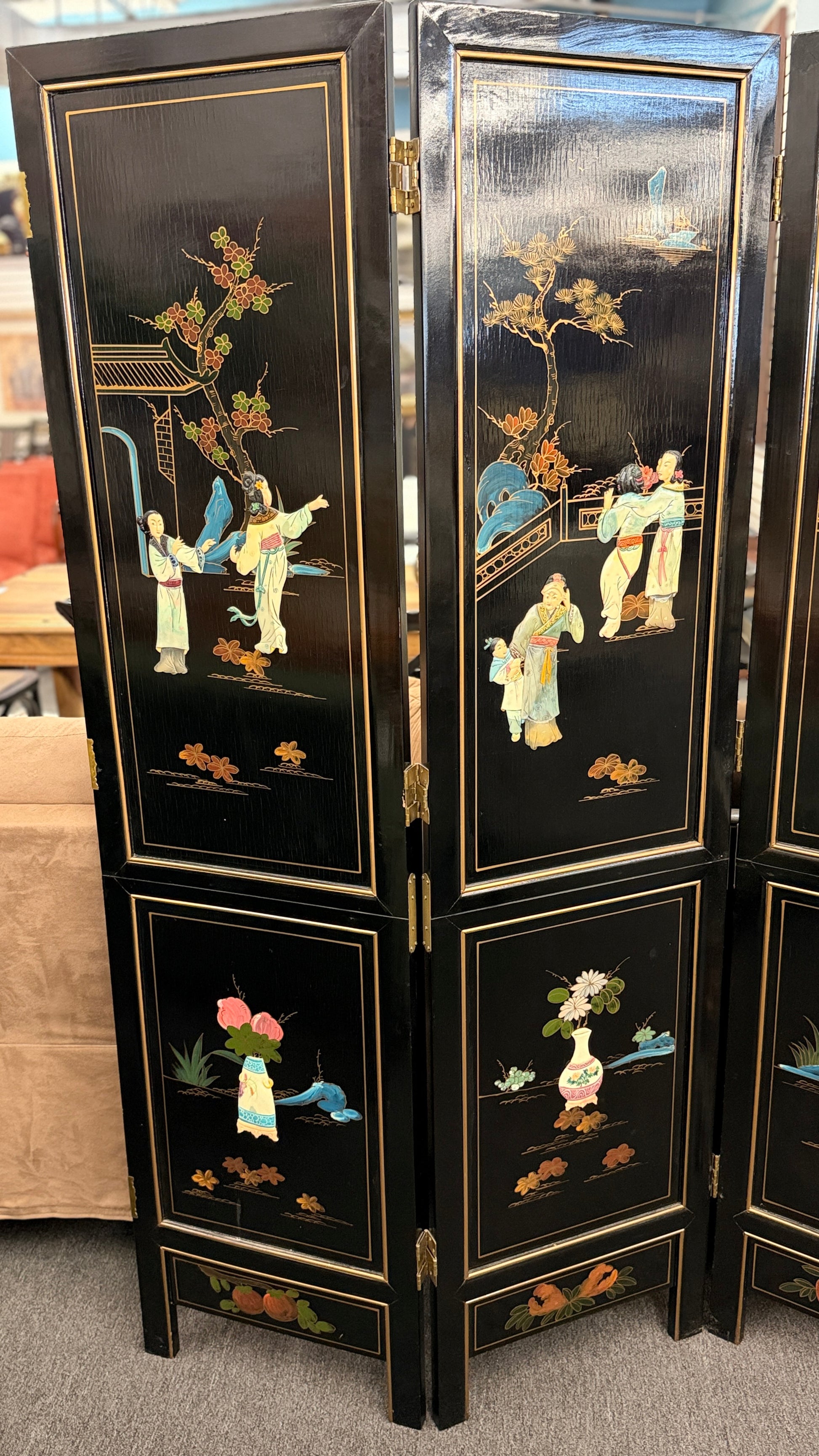 Traditional Chinoiserie multi panel wood folding room divider and privacy screen featuring intricate decorative designs on a carpeted floor at 2nd Debut Houston consignment showroom