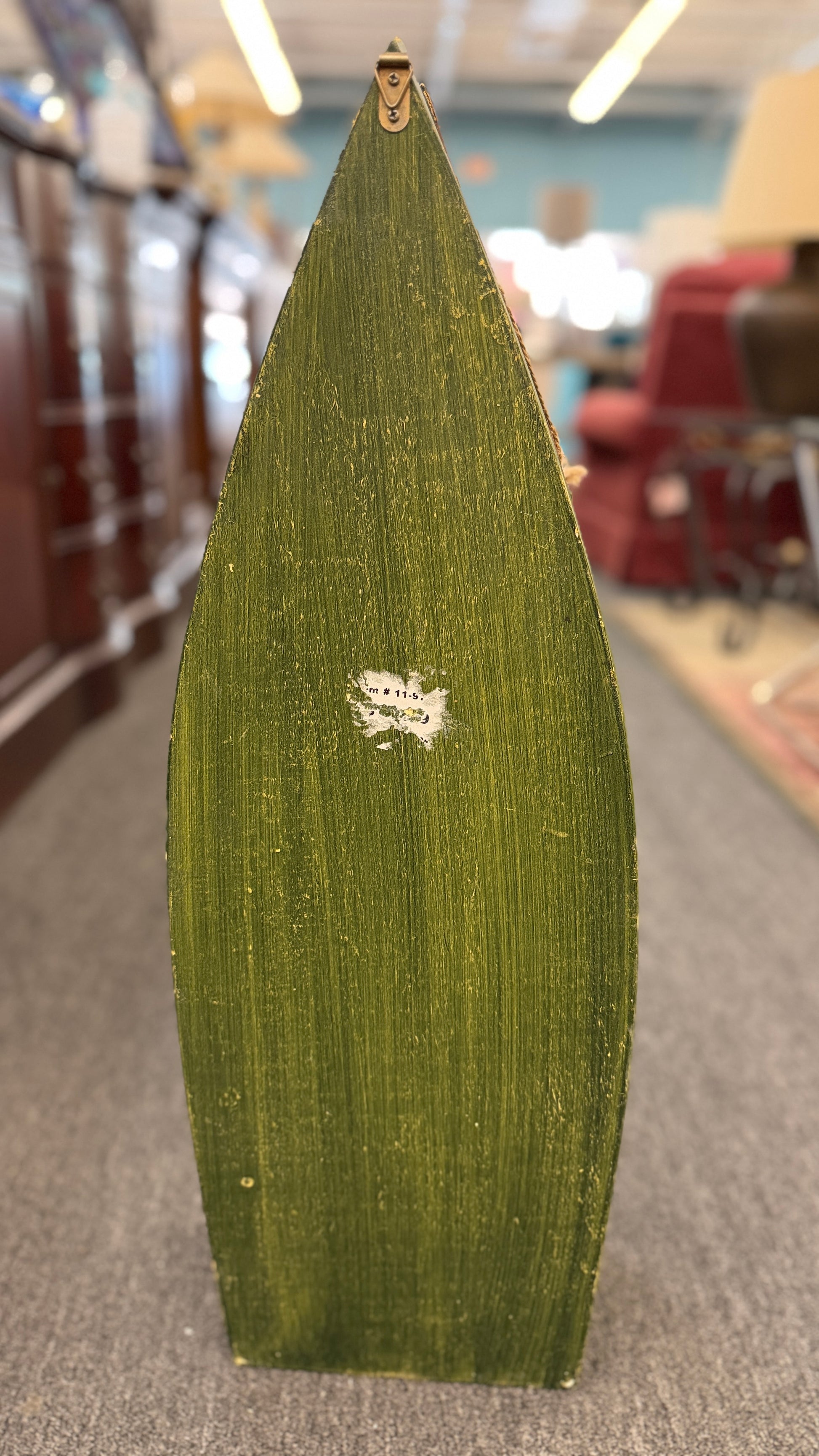 Green leaf with a logo on a blurred indoor background