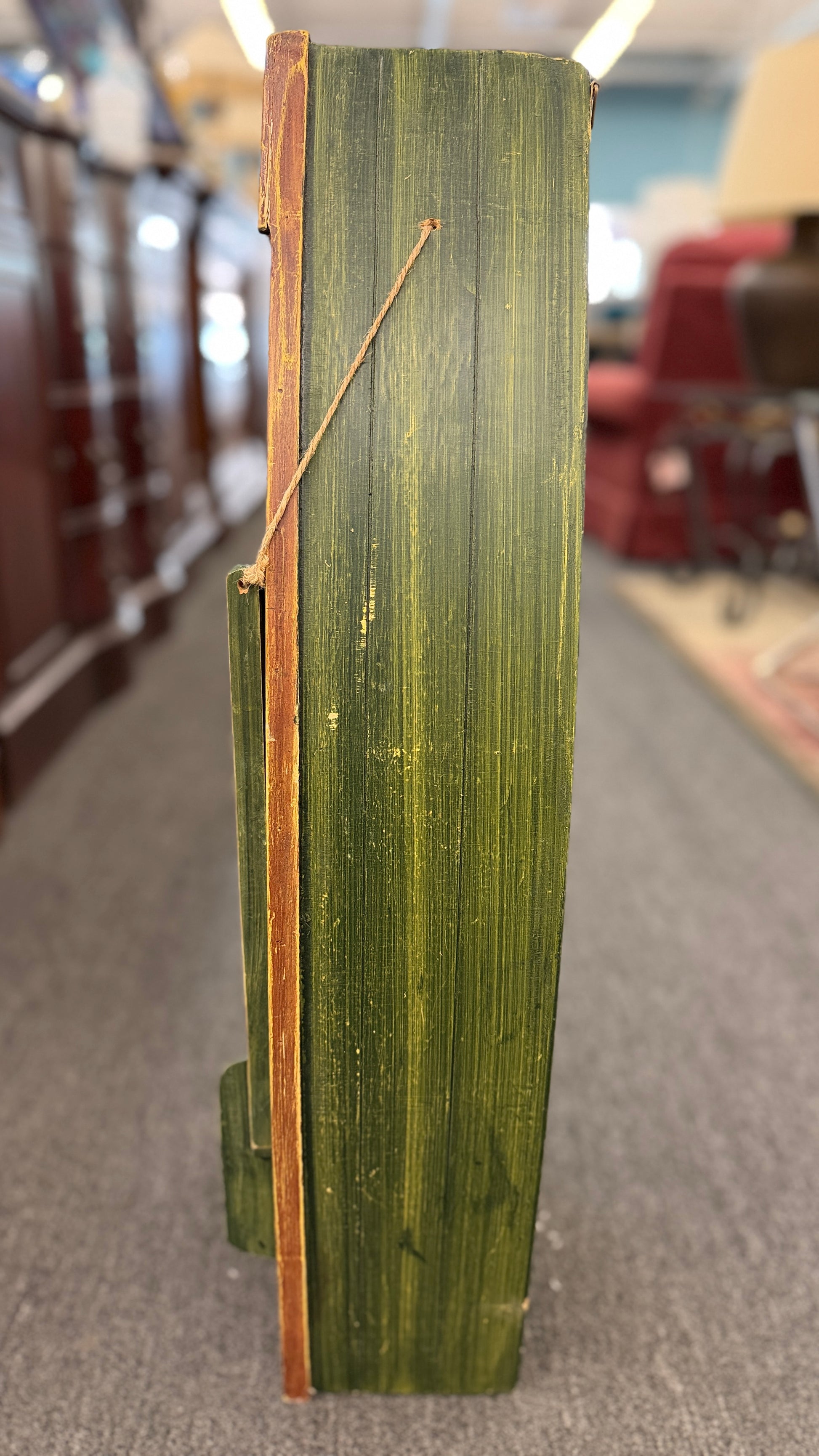Green wooden box with a gold handle on a carpeted floor