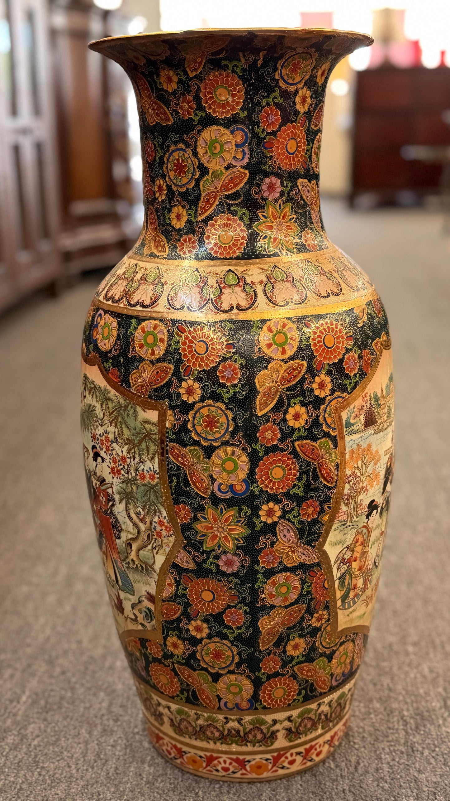Decorative vase with intricate floral and paisley patterns on a neutral background