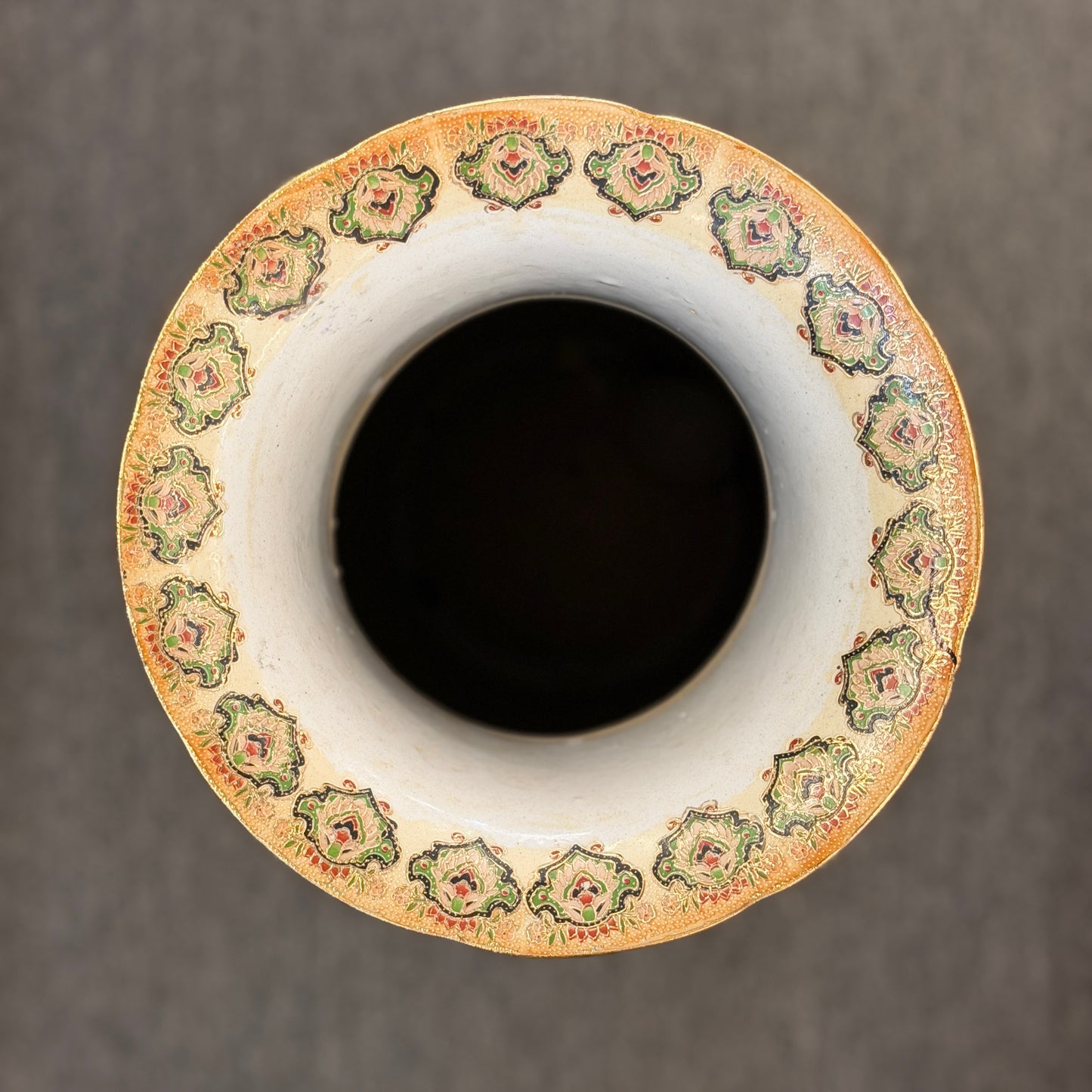 Decorative ceramic vase with a patterned rim on a dark background