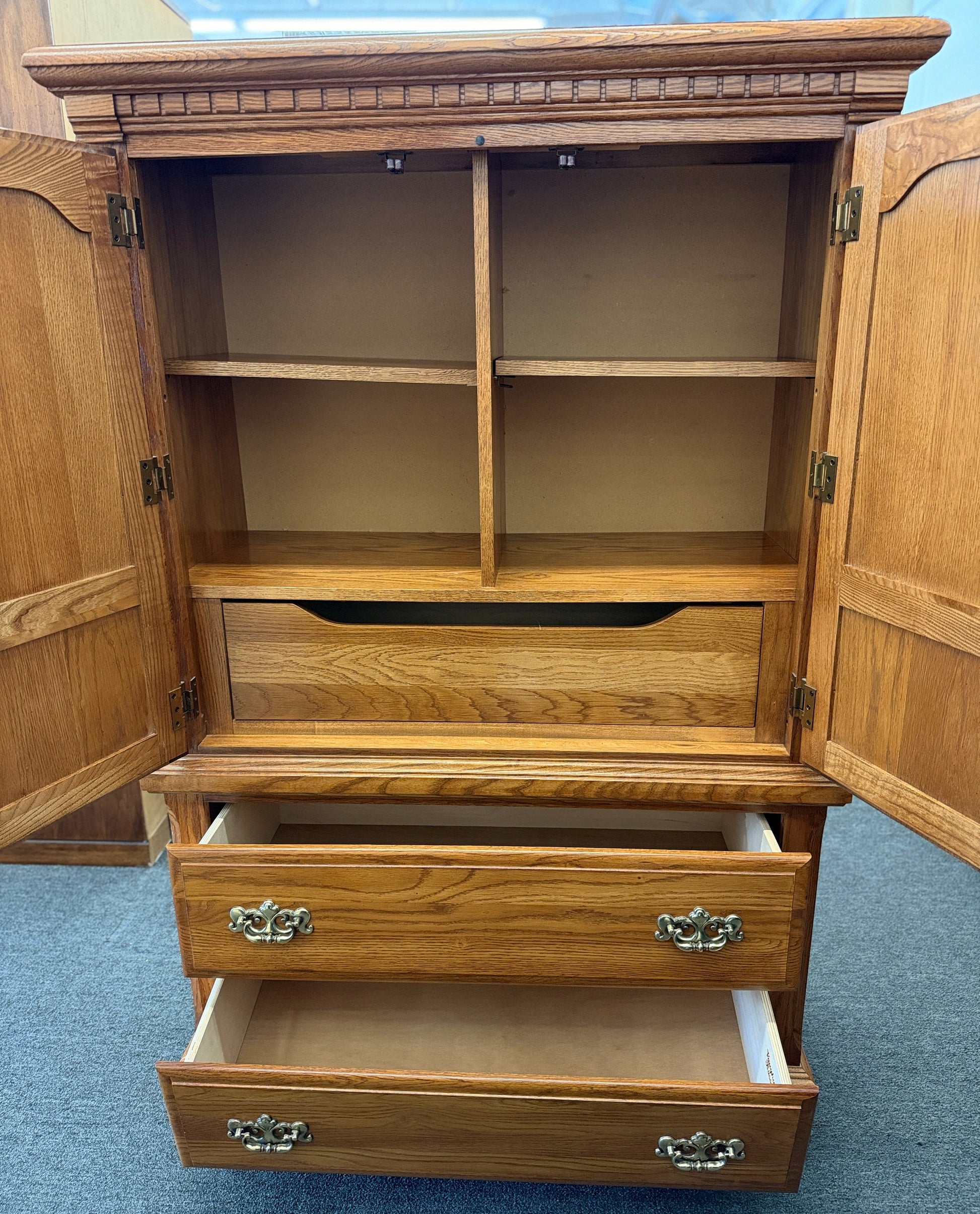 Traditional oak wood armoire and wardrobe chest featuring two doors and two lower drawers at 2nd Debut Houston consignment showroom