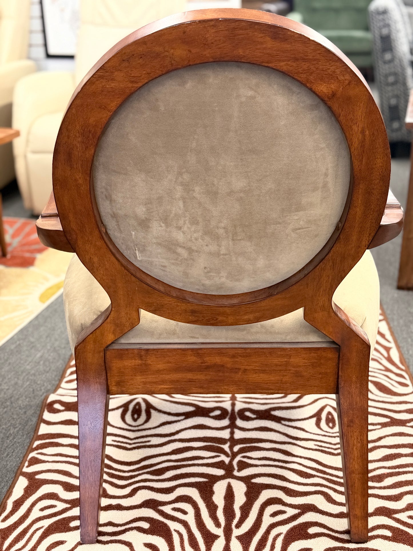 Wooden chair with a round backrest and zebra print seat cover.
