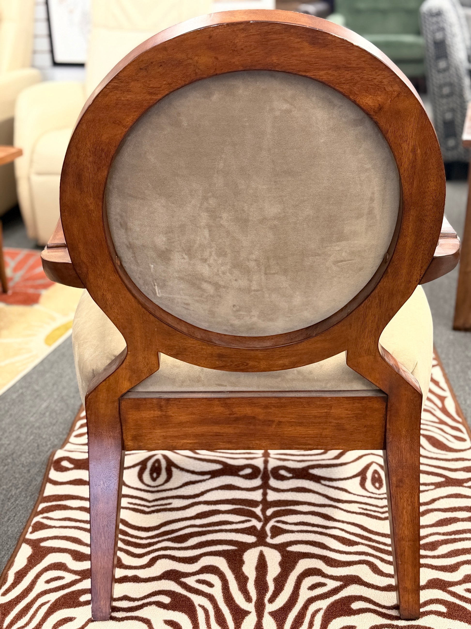 Wooden chair with a round backrest and zebra print seat cover.