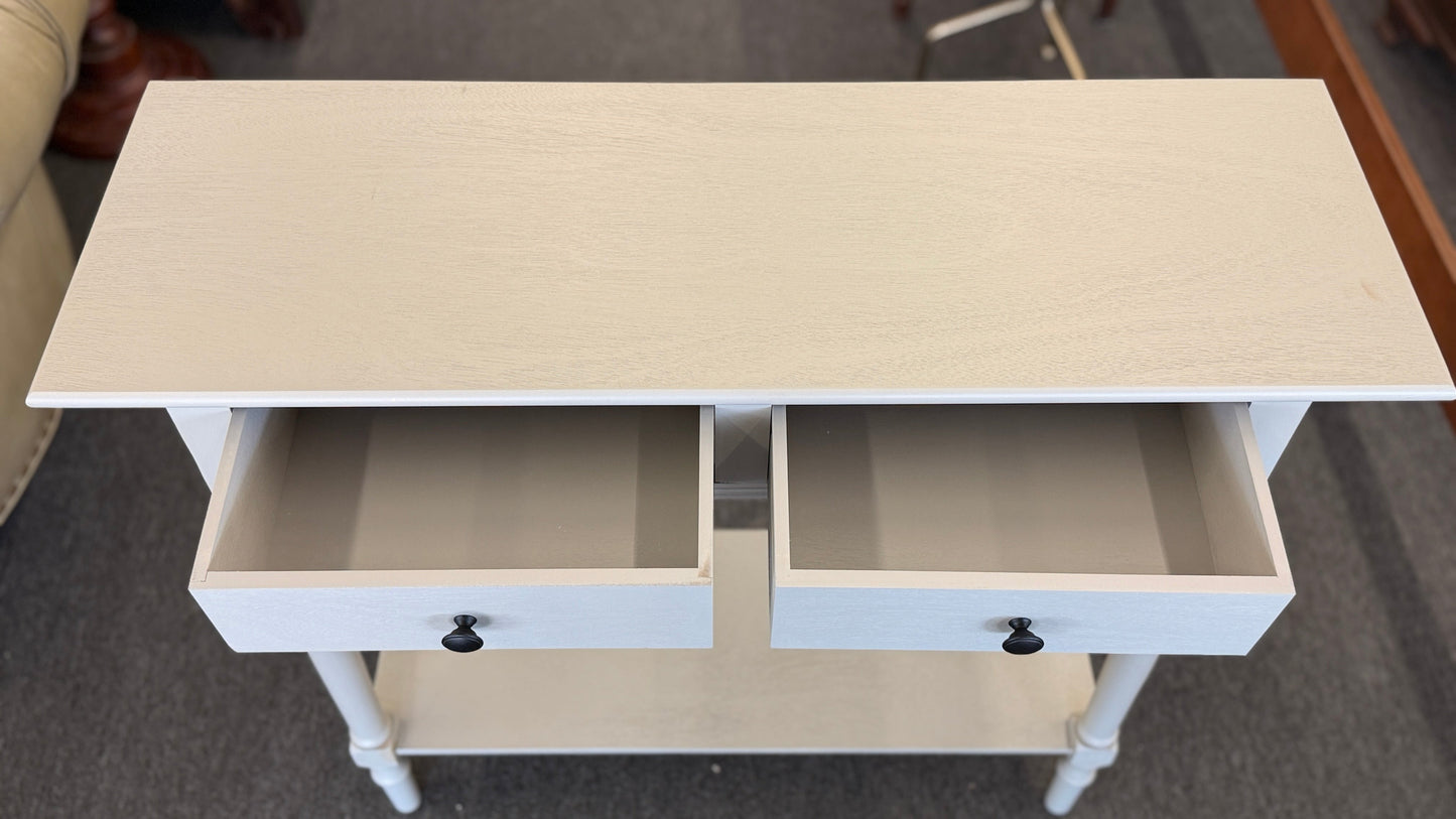 Small white cabinet with a door open on a gray floor.