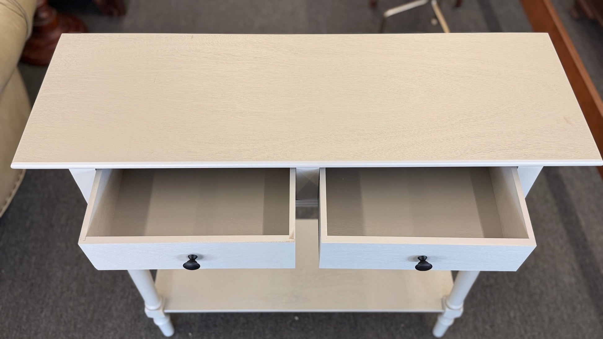 Small white cabinet with a door open on a gray floor.