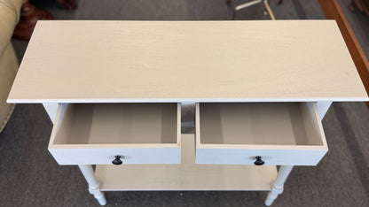 Small white cabinet with a door open on a gray floor.