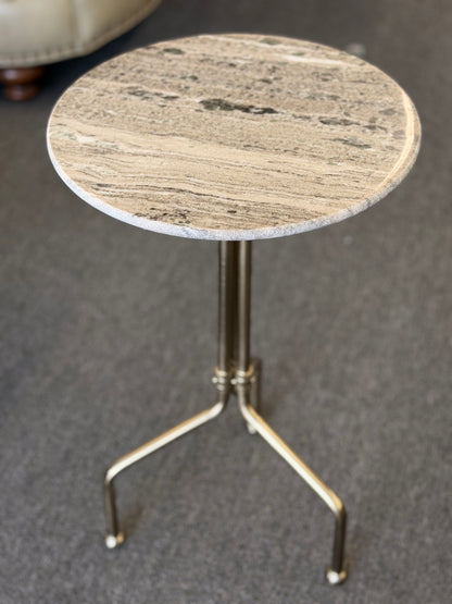 Small round table with marble-like top and metal base on a gray background