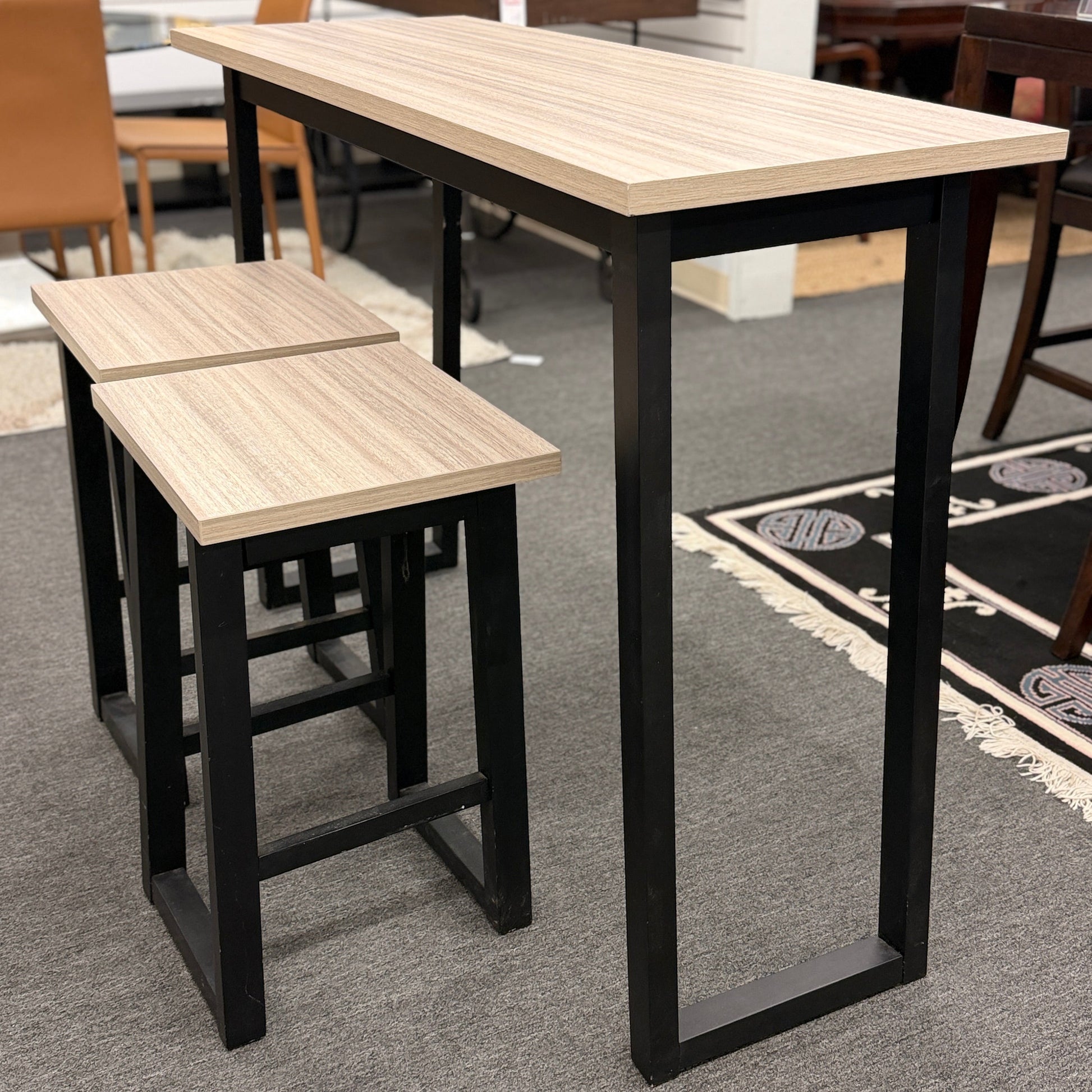 High table with two matching stools in a room setting