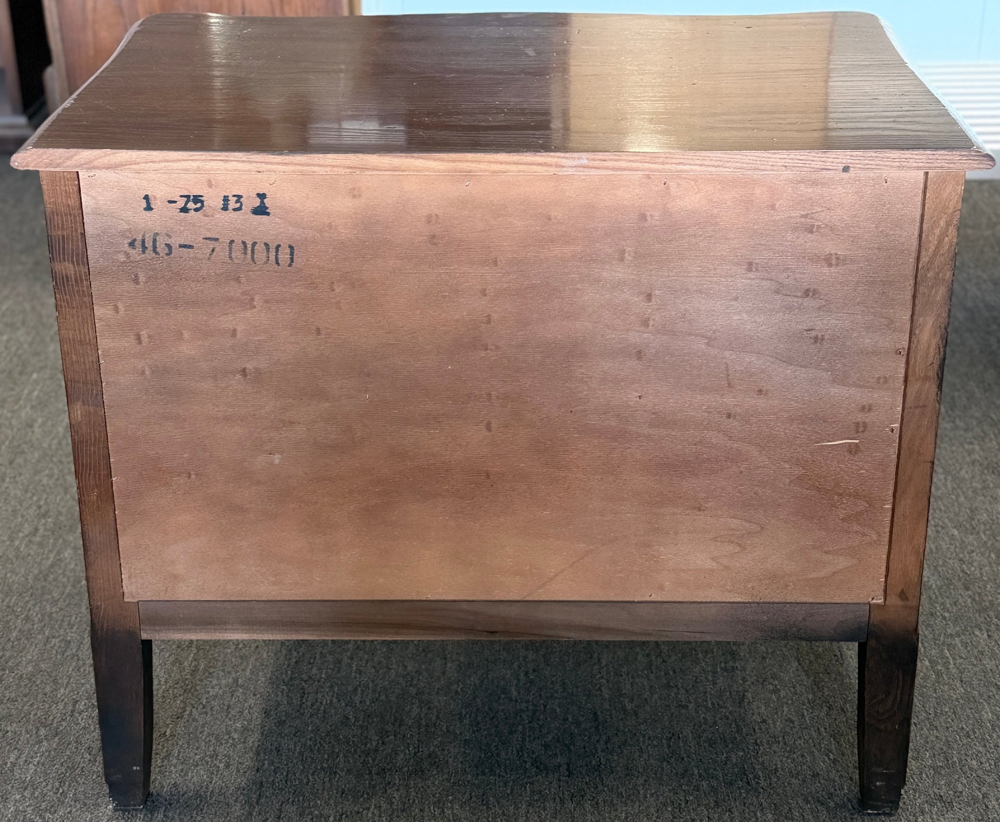 Wooden box with visible markings on a carpeted floor