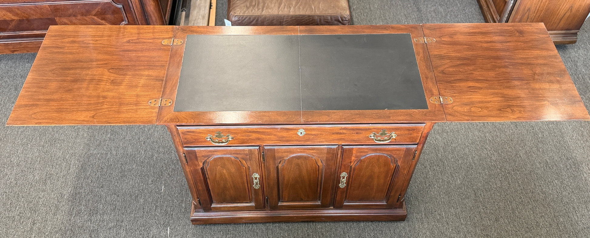 Traditional expandable wood buffet server and sideboard featuring three arched cabinet doors and brass handles at 2nd Debut Houston consignment showroom