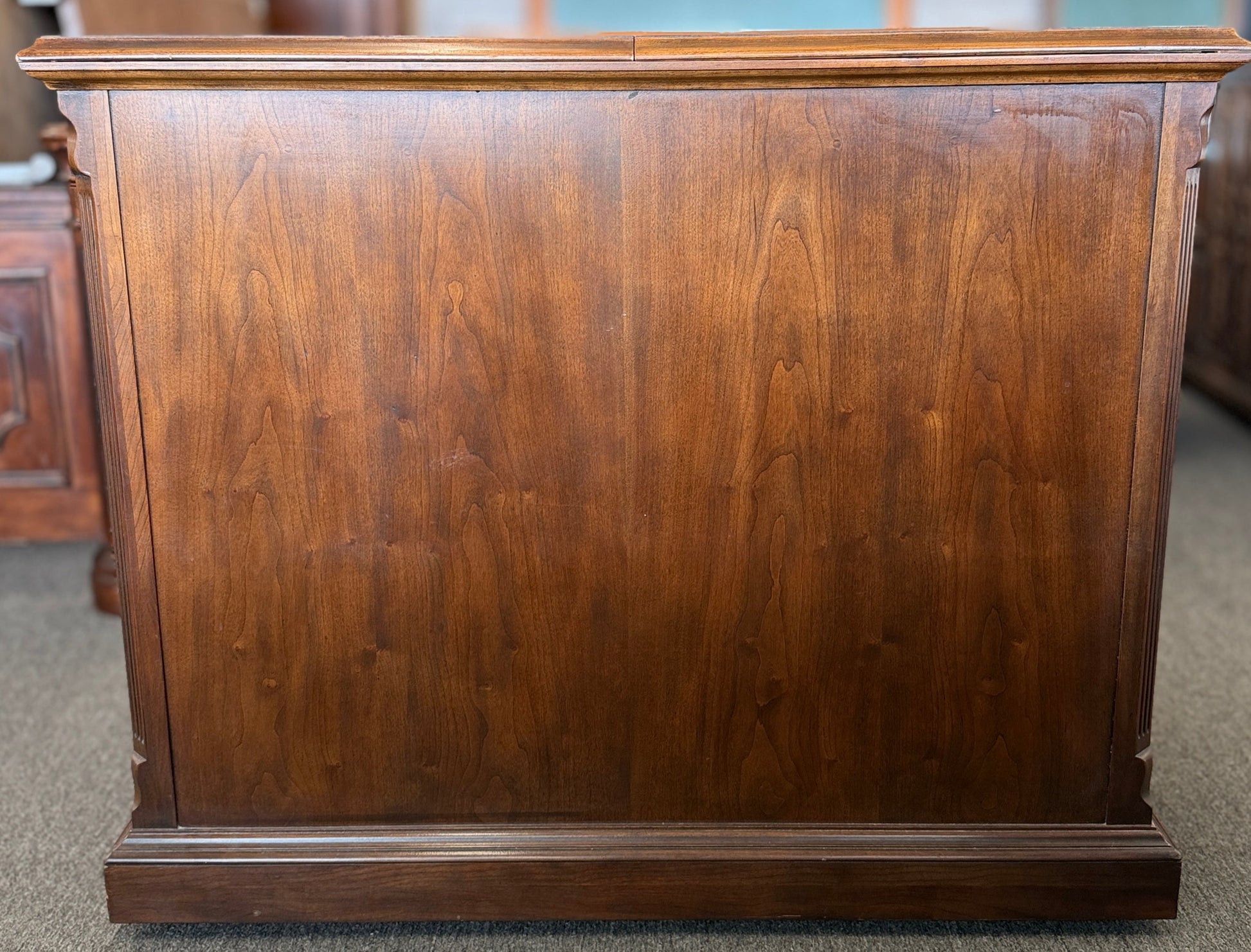 Wooden dresser with a reflective surface in a room setting