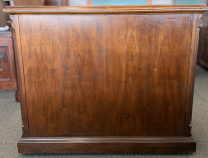Wooden dresser with a reflective surface in a room setting