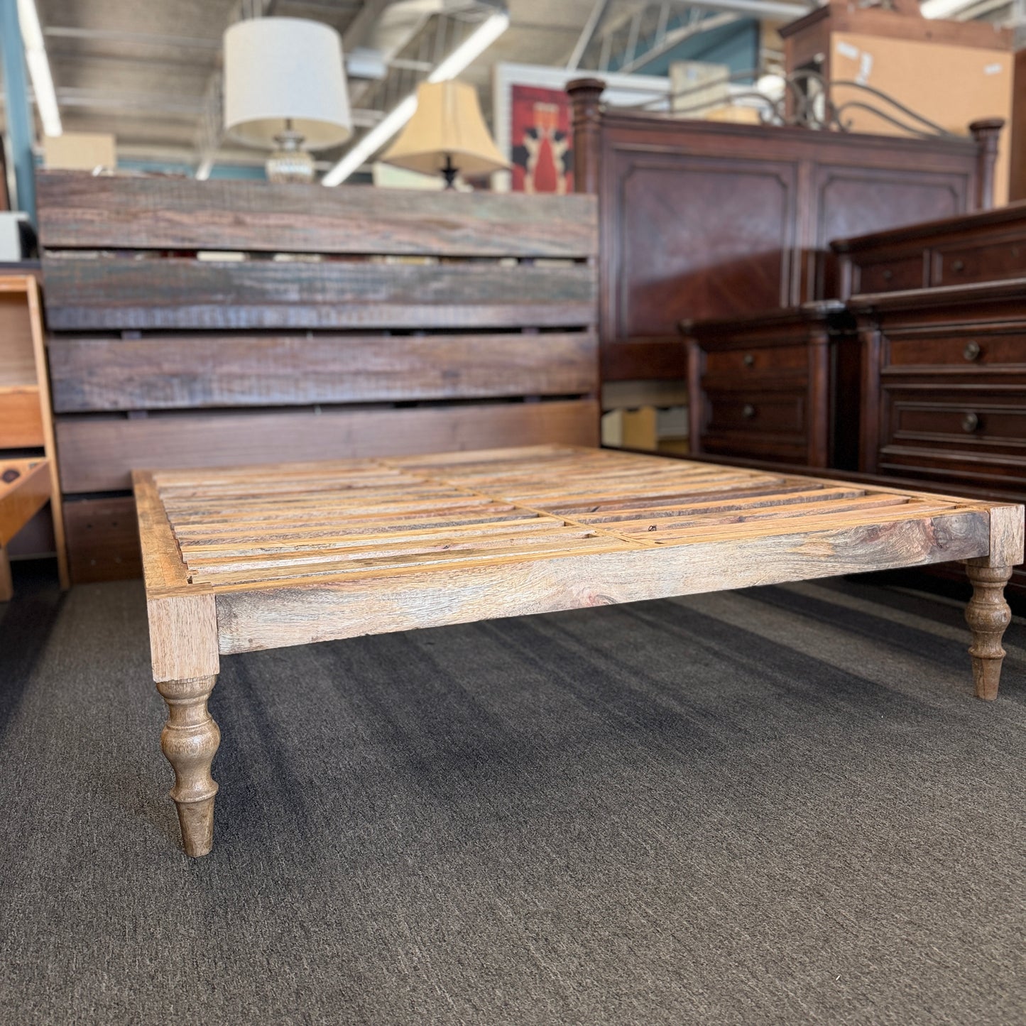 Wooden bed frame in a furniture store setting