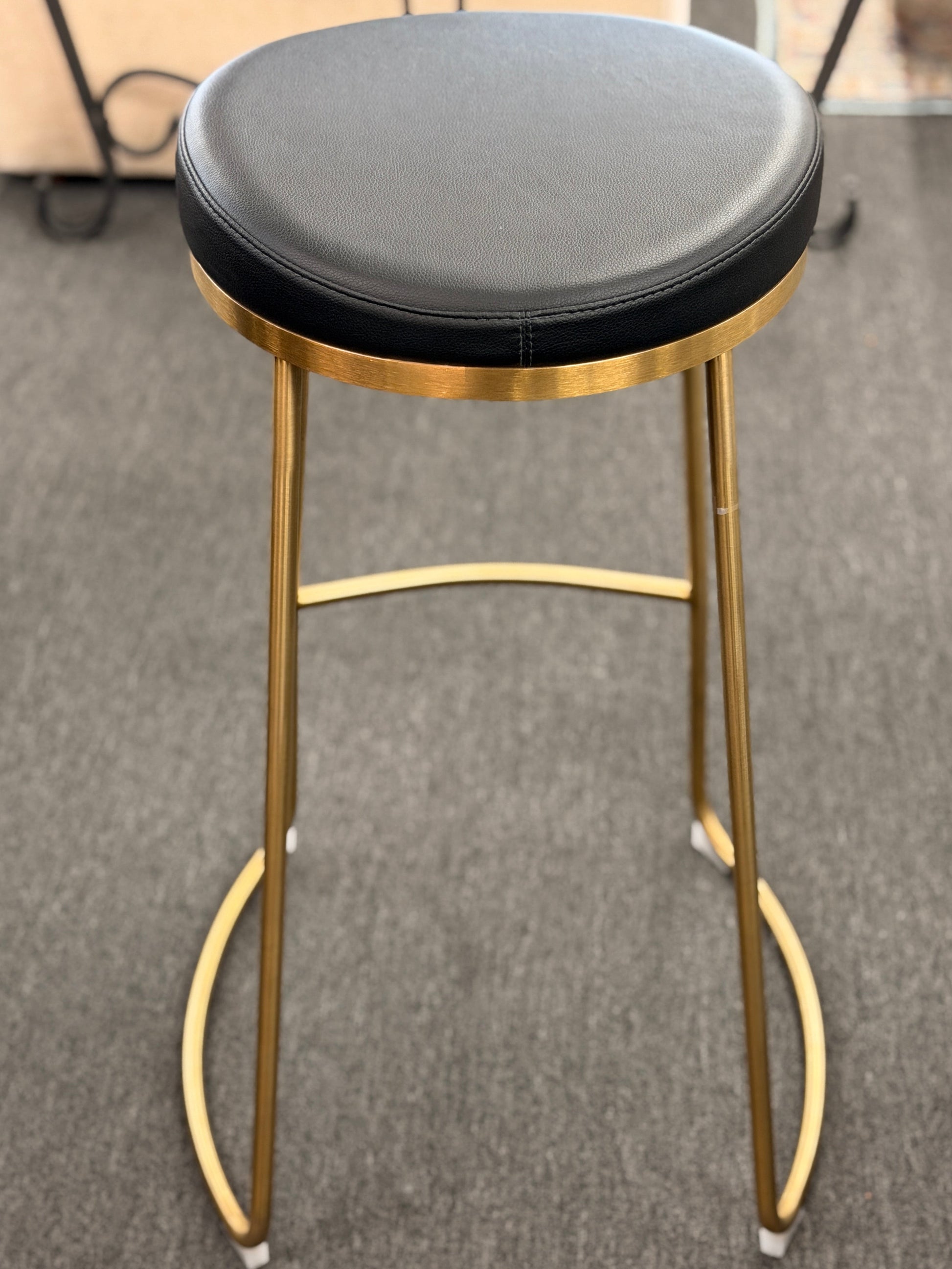 Modern geometric brass and black leather barstool set featuring slender metal legs and a half circle footrest at 2nd Debut Houston consignment showroom