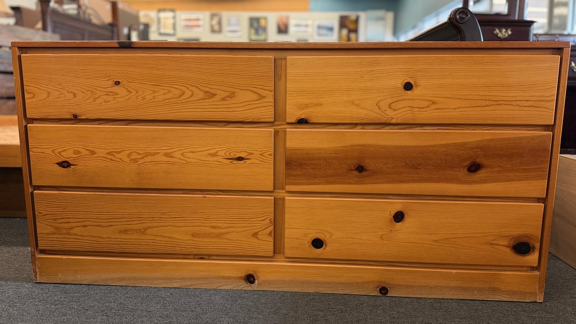 Wooden dresser with multiple drawers in a store setting