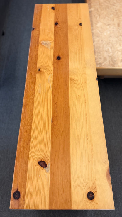 Wooden bench with a visible brand label on a dark surface