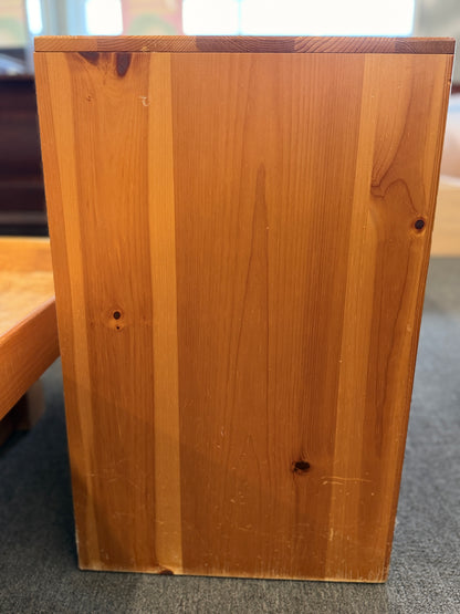 Wooden box with a visible grain pattern on a carpeted floor.
