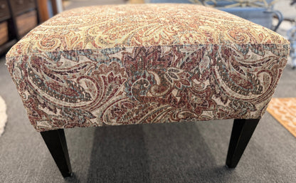 Patterned ottoman on a carpeted floor