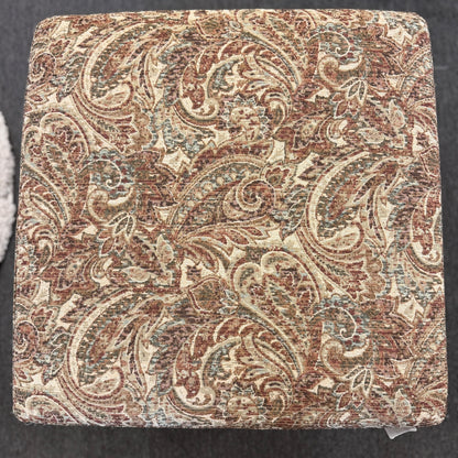 Square fabric swatch with intricate paisley pattern on a dark background