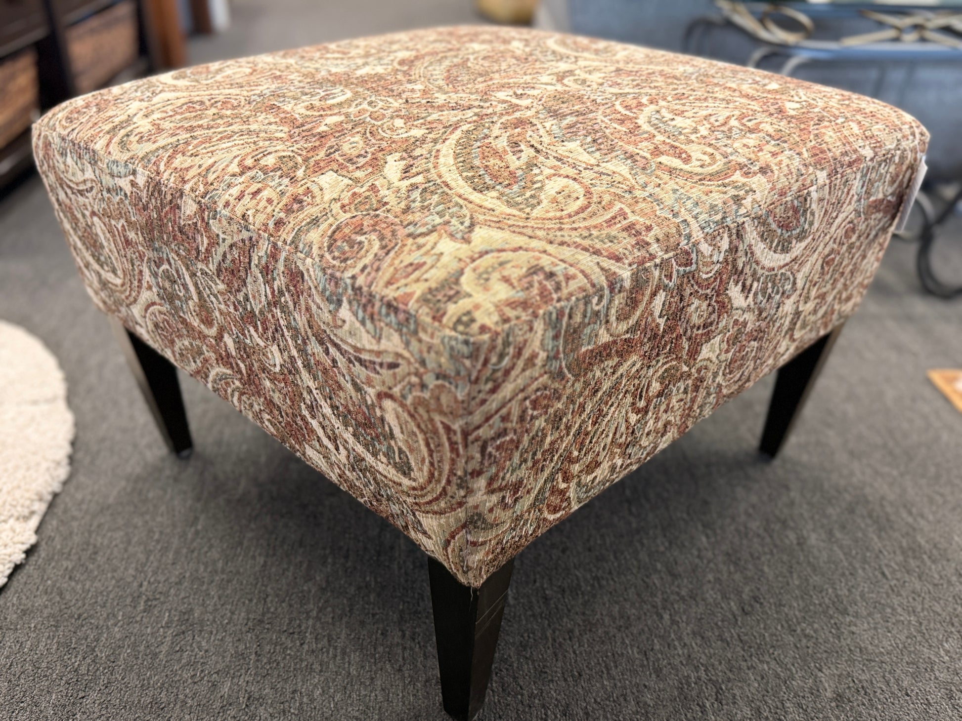 Patterned ottoman on a carpeted floor