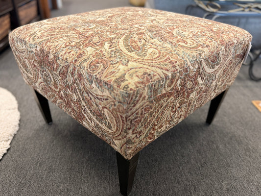 Patterned ottoman on a carpeted floor