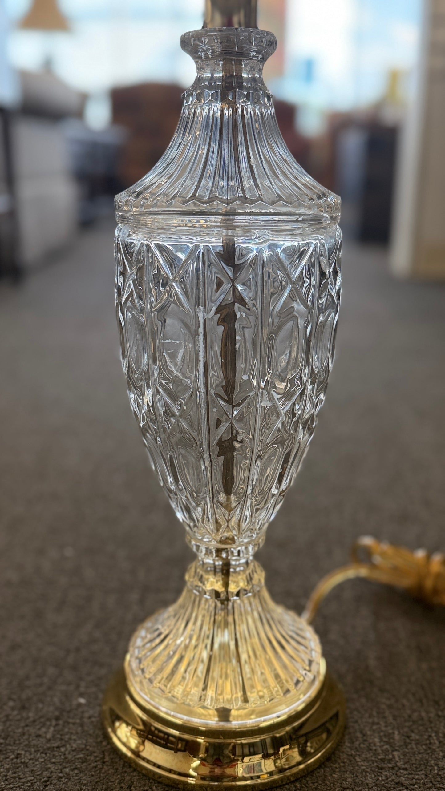 A traditional 29-inch table lamp featuring a diamond-cut crystal urn-shaped body, a polished gold base, and a classic white flared fabric lampshade.
