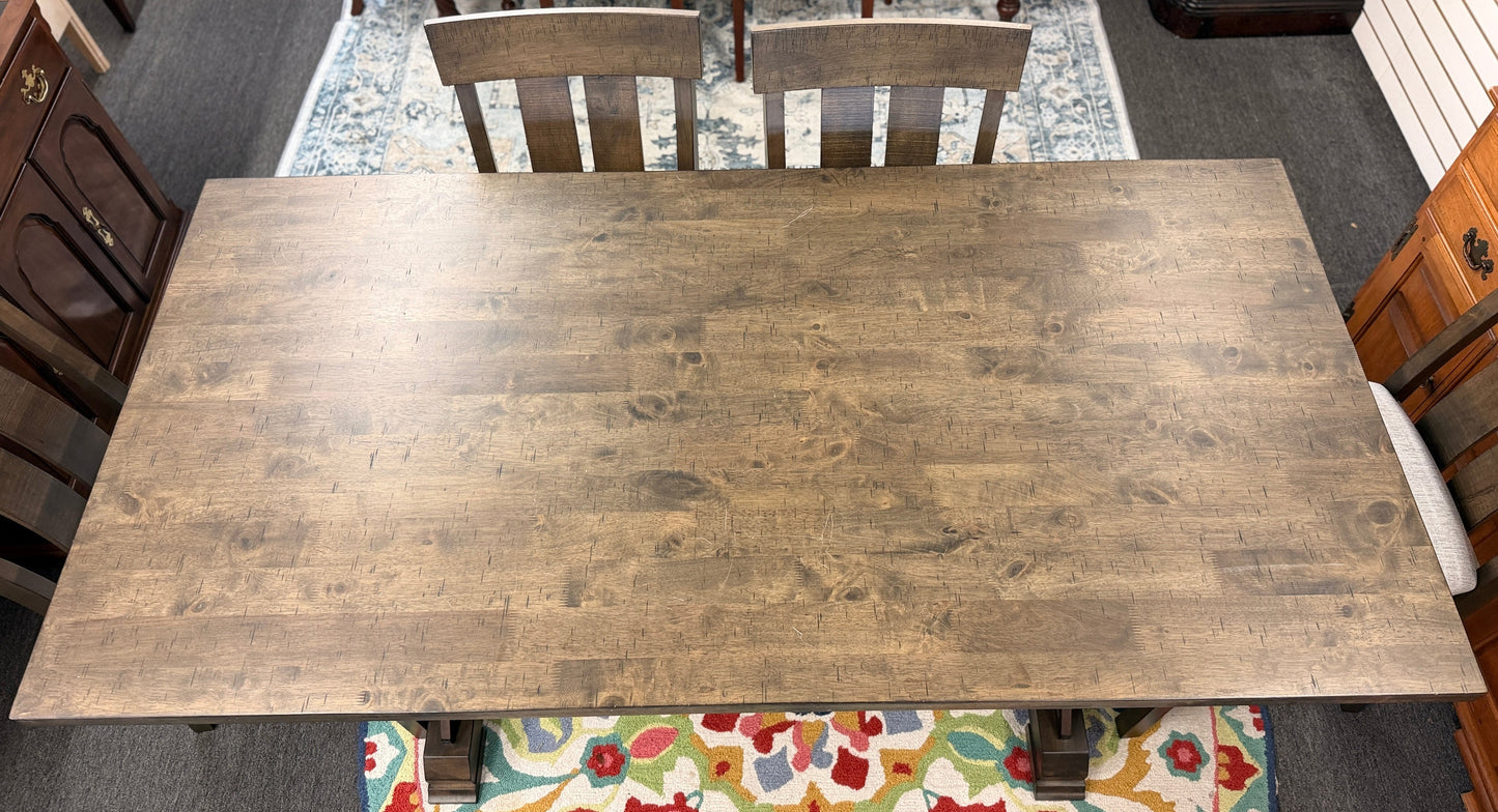 A rustic-modern counter-height dining set featuring a long wood and iron table, four matching slat-back chairs, and a long upholstered dining bench.
