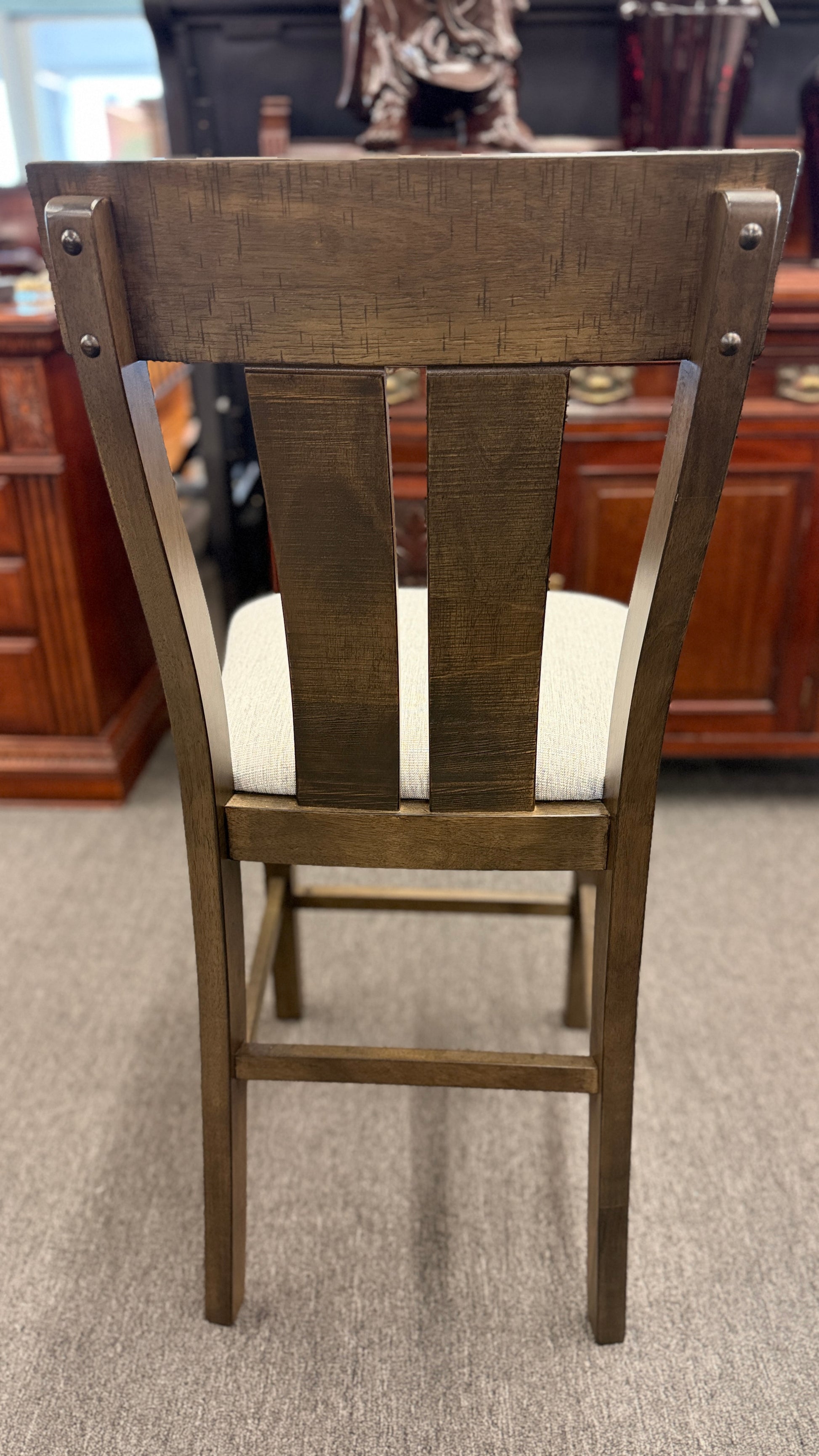A rustic-modern counter-height dining set featuring a long wood and iron table, four matching slat-back chairs, and a long upholstered dining bench.