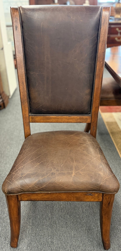 A formal 7-piece dining set featuring an oval dark wood extension table with a carved pedestal base and six upholstered high-back chairs with rolled silhouettes.