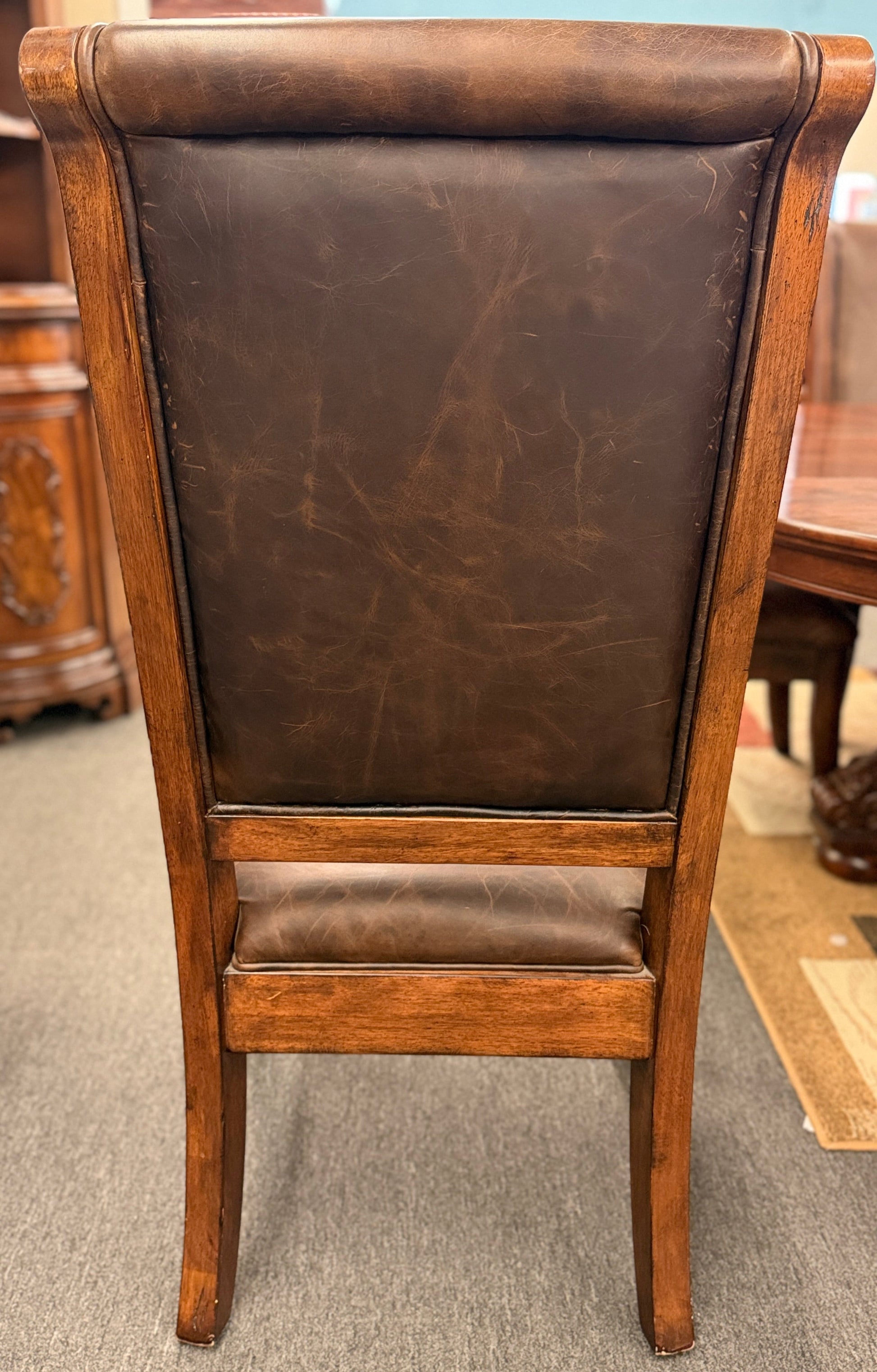 A formal 7-piece dining set featuring an oval dark wood extension table with a carved pedestal base and six upholstered high-back chairs with rolled silhouettes.
