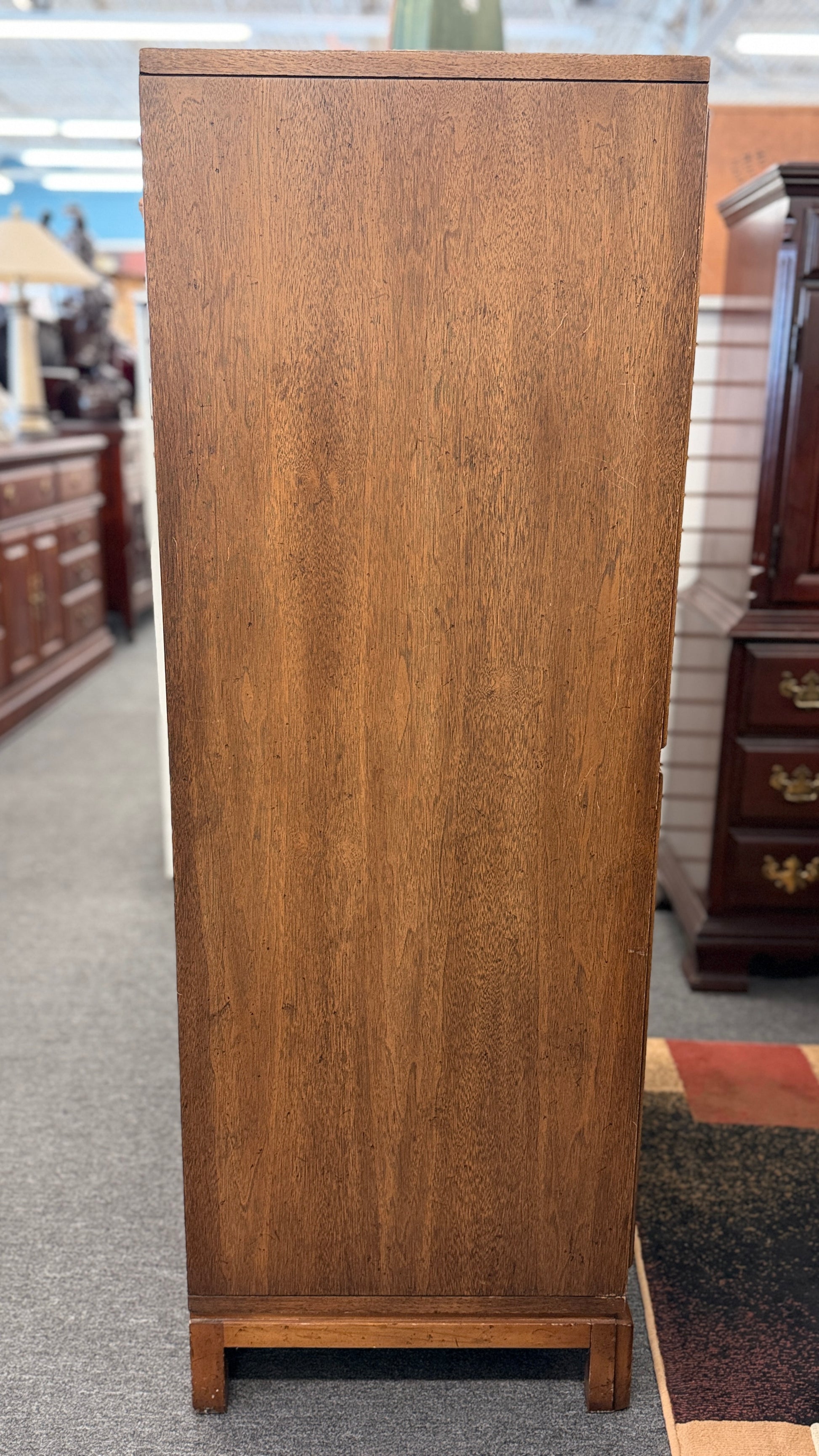 A vintage wooden armoire storage cabinet featuring a symmetric four-panel door facade with recessed molding and antiqued brass ring pull handles.