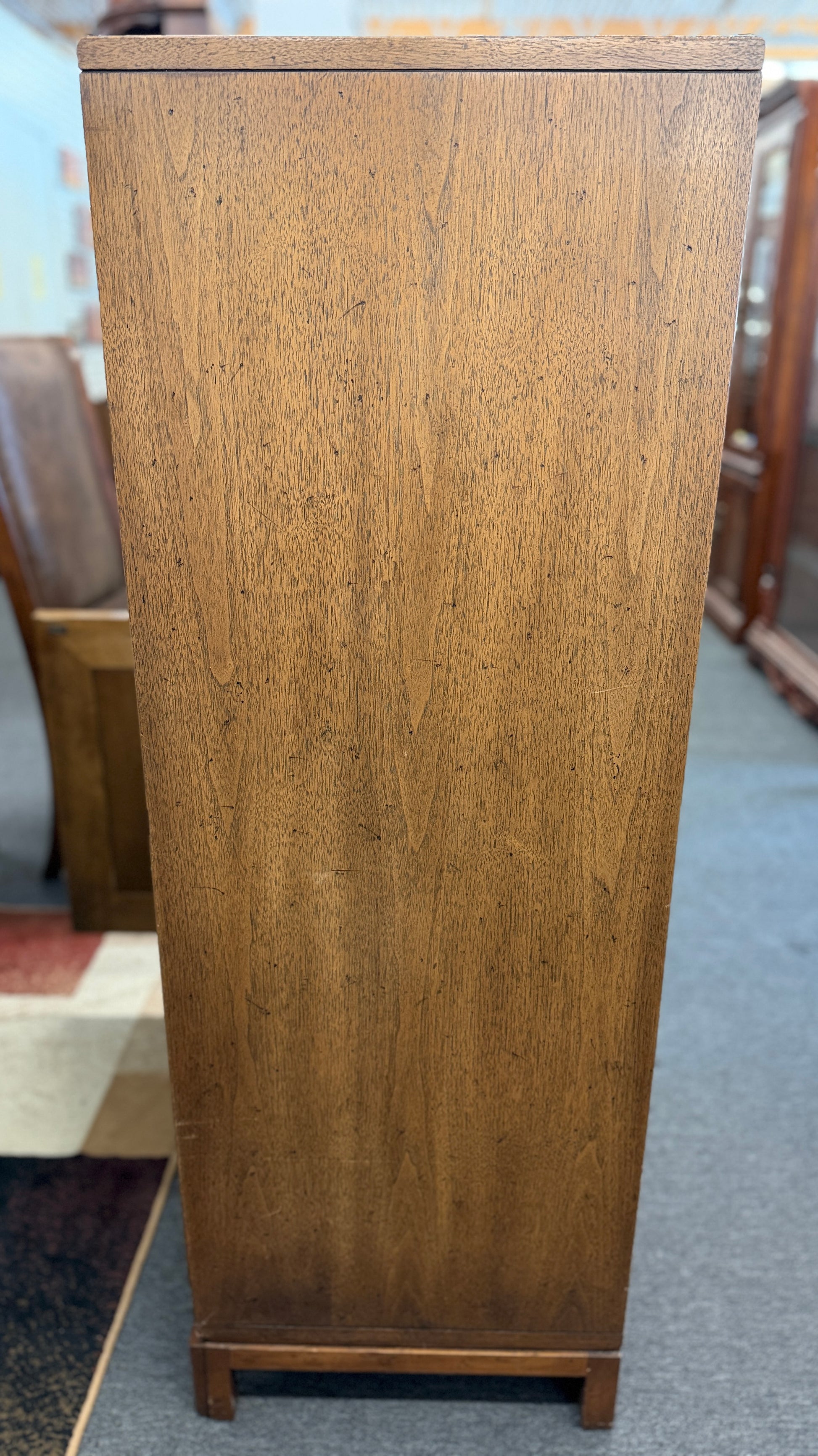 A vintage wooden armoire storage cabinet featuring a symmetric four-panel door facade with recessed molding and antiqued brass ring pull handles.