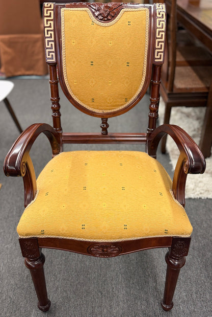 A 5-piece traditional game table set featuring a square wood table with a green felt surface and cup holders, surrounded by four rolling armchairs in yellow patterned upholstery with a Greek key trim.