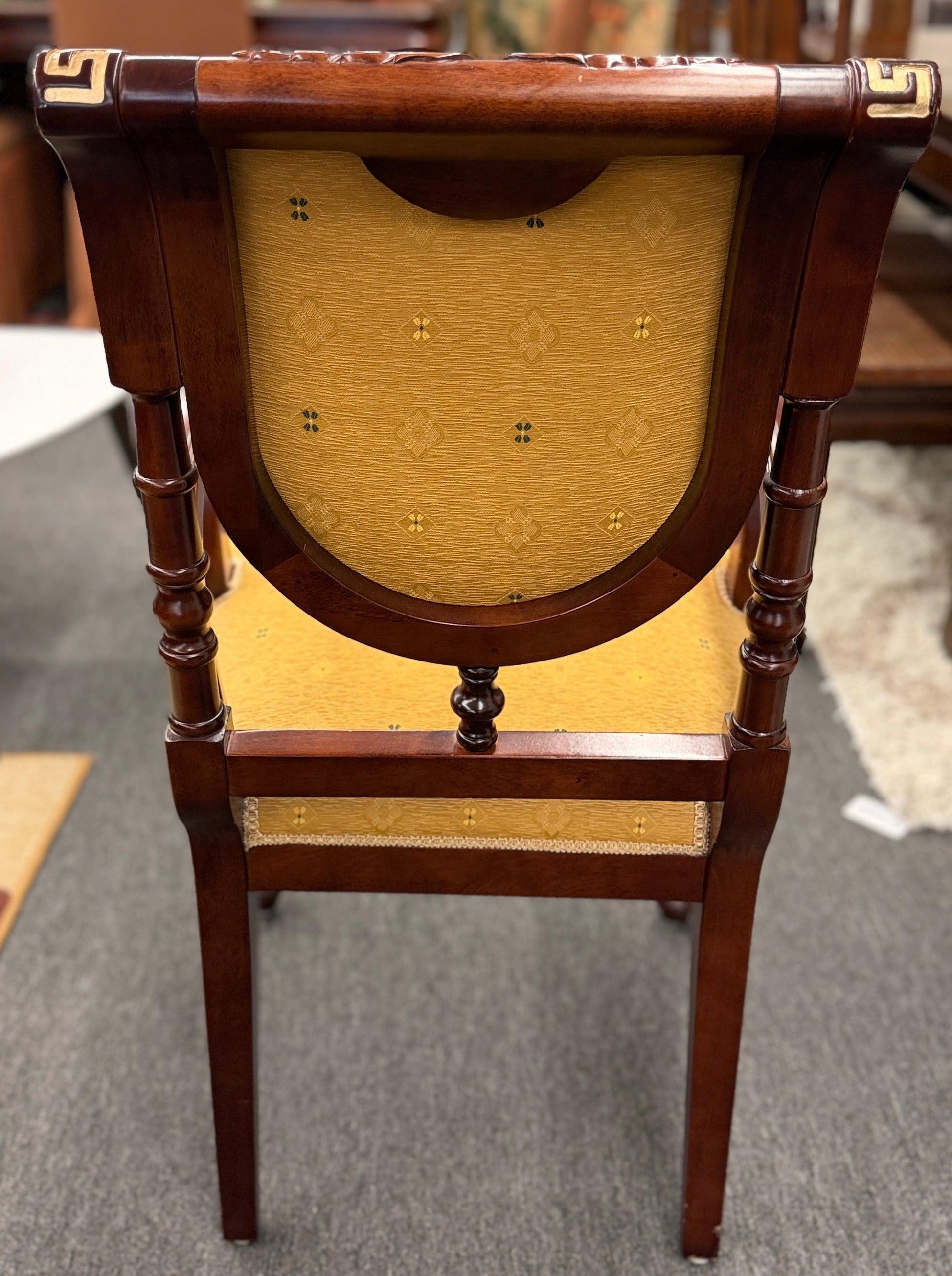A 5-piece traditional game table set featuring a square wood table with a green felt surface and cup holders, surrounded by four rolling armchairs in yellow patterned upholstery with a Greek key trim.