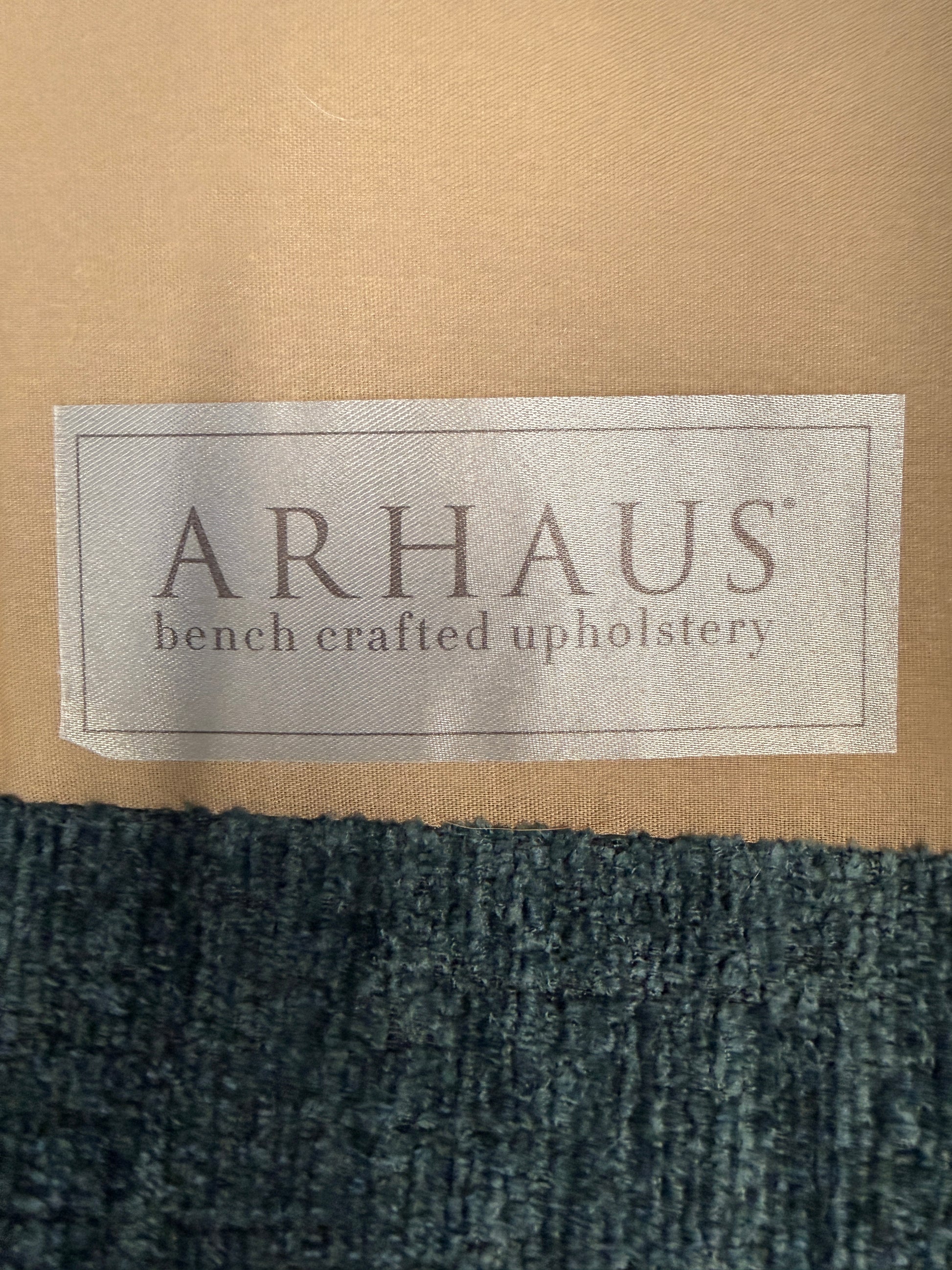 A premium Arhaus plush upholstered swivel armchair in excellent condition, featuring rolled arms, a thick seat cushion, and a high backrest.