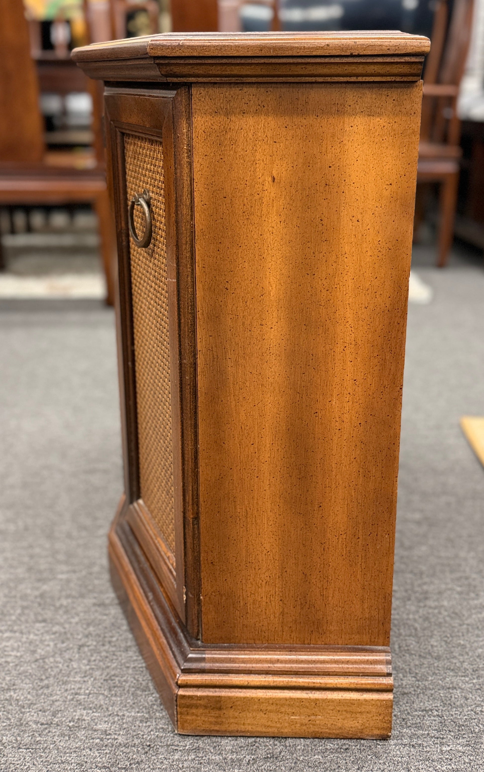 A classic wood accent cabinet featuring three front panels with decorative metal ring-pull hardware and a clean-lined wood frame.