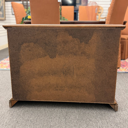 A classic wood accent cabinet featuring three front panels with decorative metal ring-pull hardware and a clean-lined wood frame.