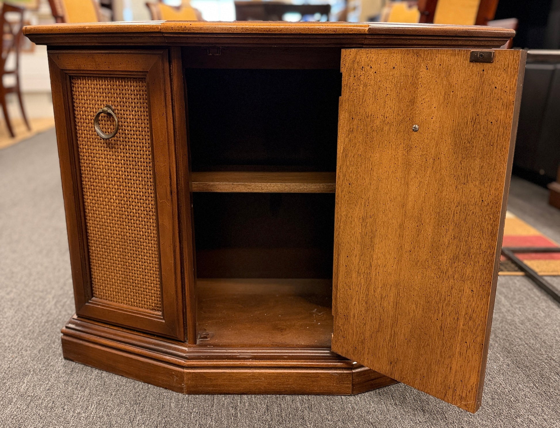 A classic wood accent cabinet featuring three front panels with decorative metal ring-pull hardware and a clean-lined wood frame.