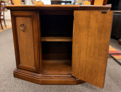 A classic wood accent cabinet featuring three front panels with decorative metal ring-pull hardware and a clean-lined wood frame.