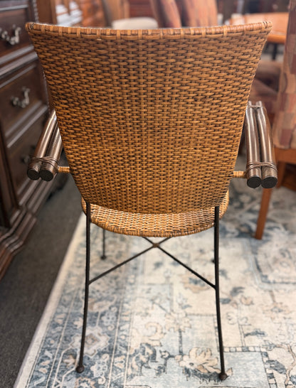 A 3-piece patio bistro set featuring a round glass-top table and two matching armchairs made of rattan and bamboo with curved metal legs.