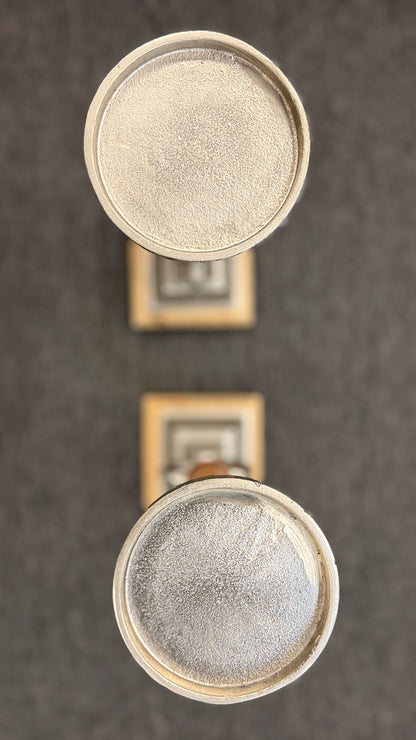 A pair of tall, eclectic pillar candle holders featuring turned wooden spindles, cast-metal open-ring accents, and tiered square plinth bases.