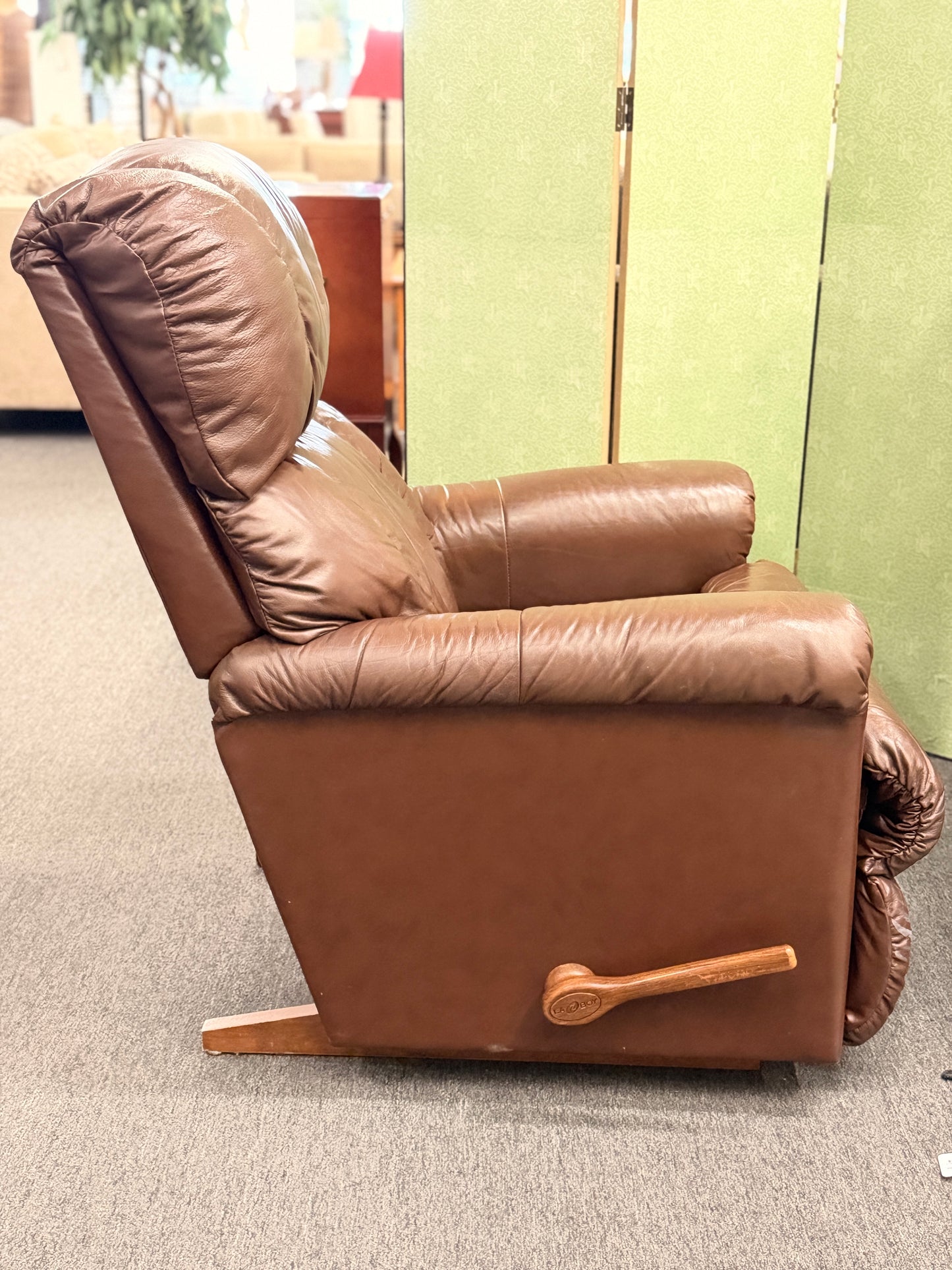 A plush, overstuffed brown leather recliner chair with thick pillowy back cushions and traditional rolled arms.