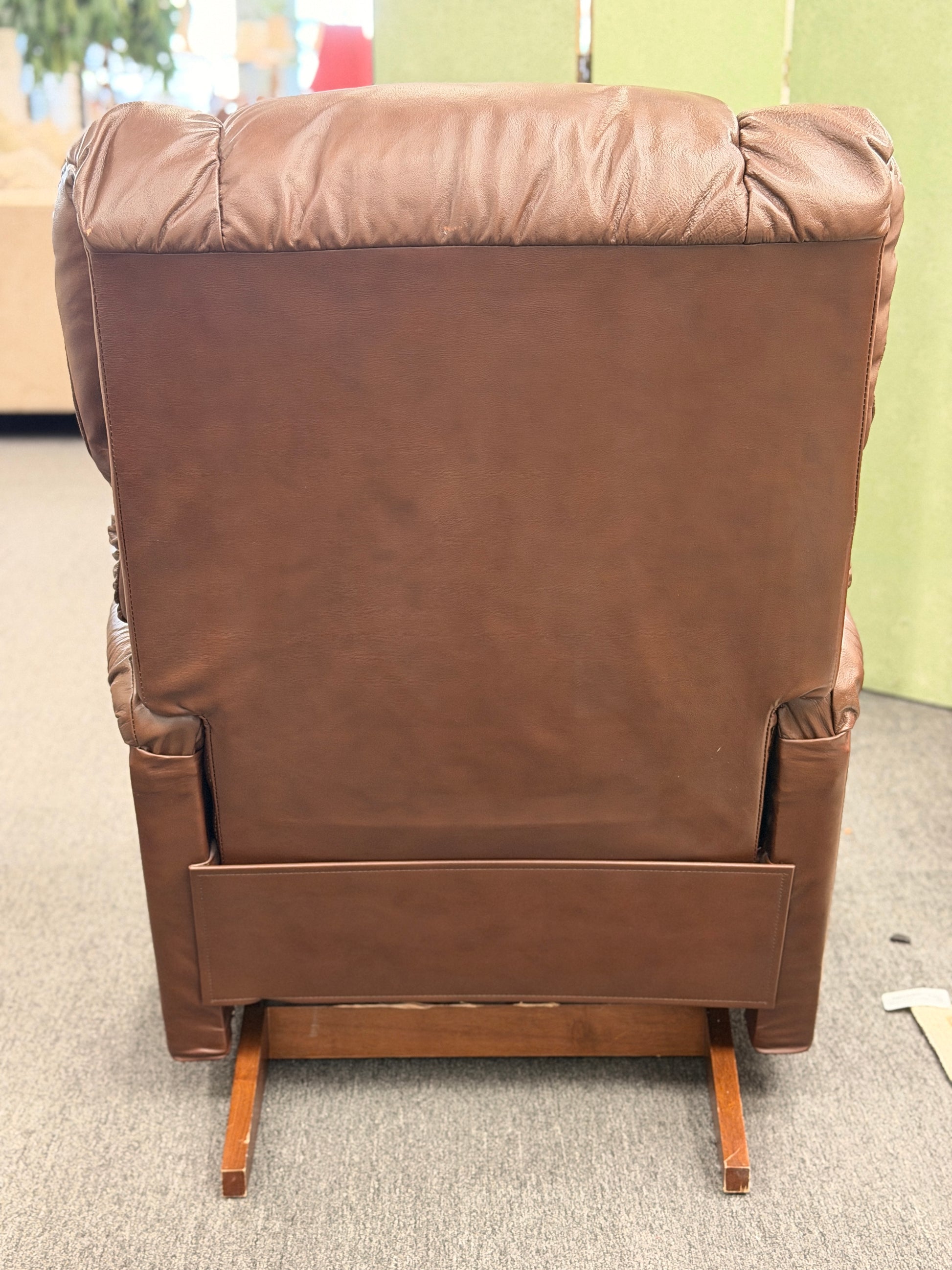 A plush, overstuffed brown leather recliner chair with thick pillowy back cushions and traditional rolled arms.