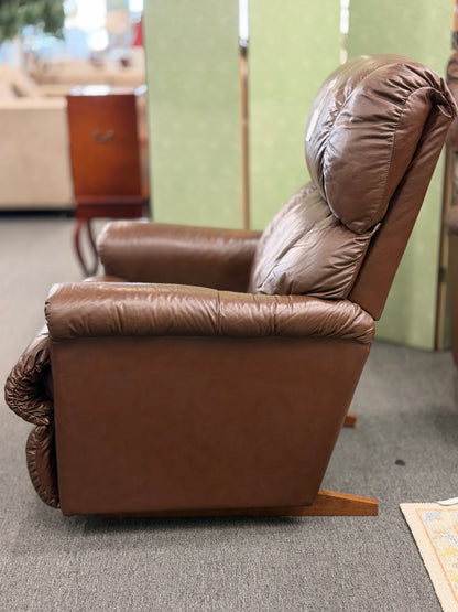 A plush, overstuffed brown leather recliner chair with thick pillowy back cushions and traditional rolled arms.