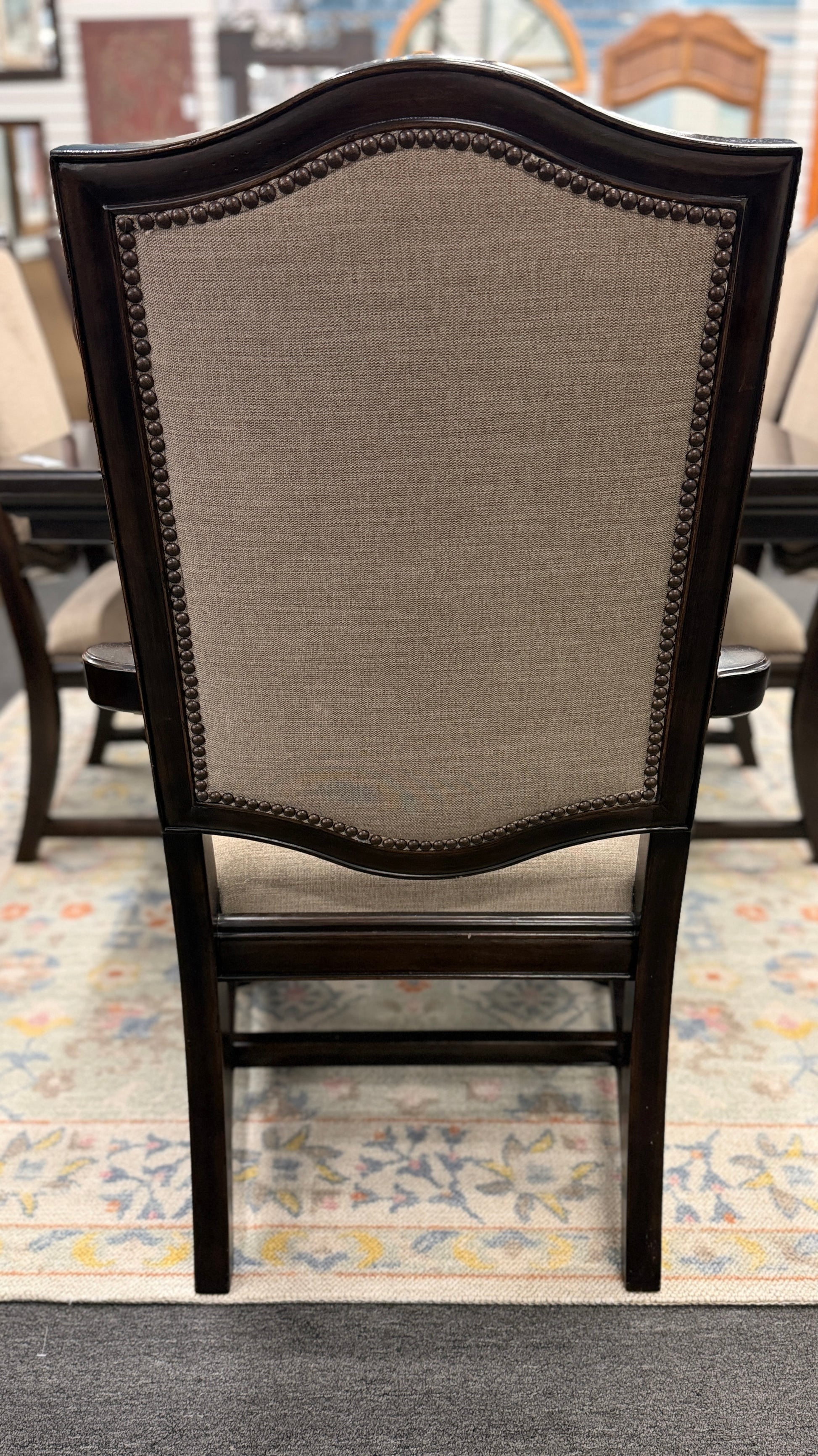 A traditional 7-piece dining set featuring a large rectangular wooden table, two high-back host armchairs, and four matching side chairs with fabric upholstery.