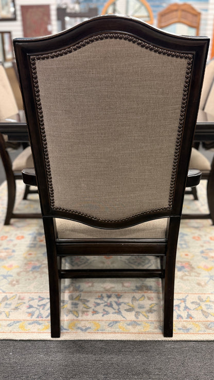 A traditional 7-piece dining set featuring a large rectangular wooden table, two high-back host armchairs, and four matching side chairs with fabric upholstery.