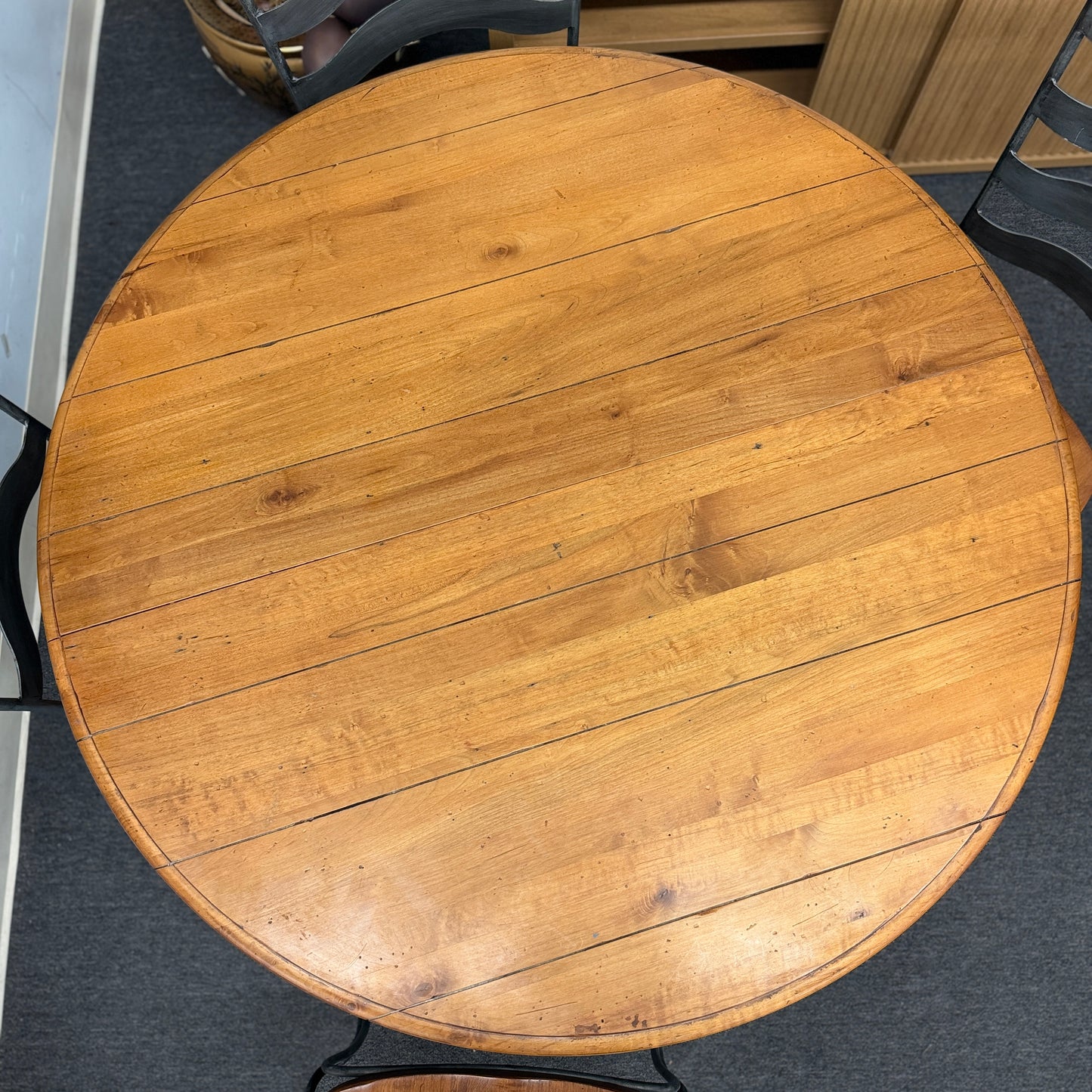 Five-piece round dining set featuring a natural wood tabletop, four matching chairs with wood seats, and decorative curved metal frames with scrollwork.