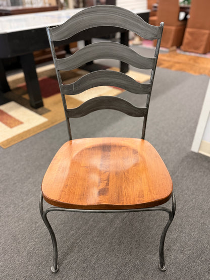 Five-piece round dining set featuring a natural wood tabletop, four matching chairs with wood seats, and decorative curved metal frames with scrollwork.